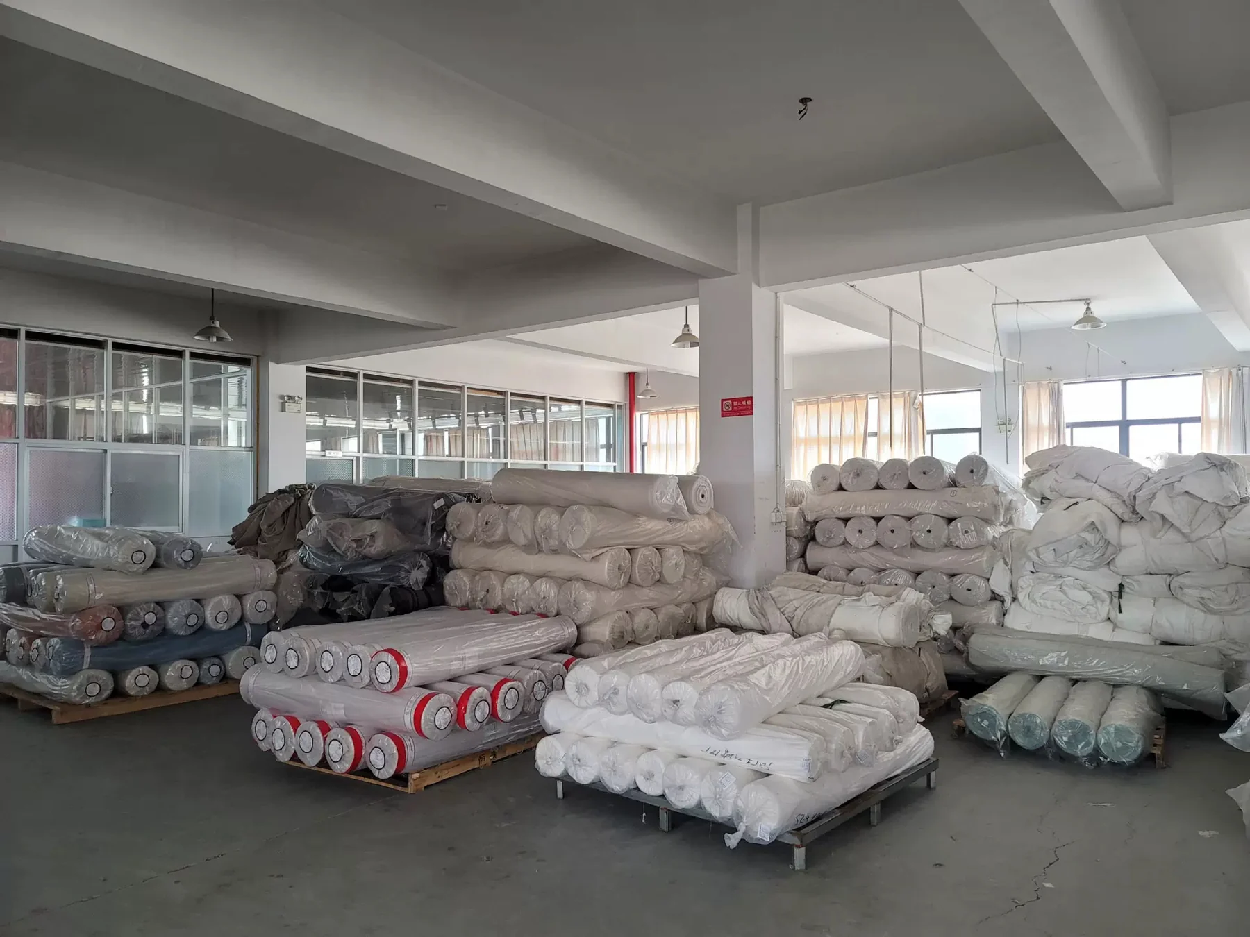 Rollos de tela organizados en la fábrica.